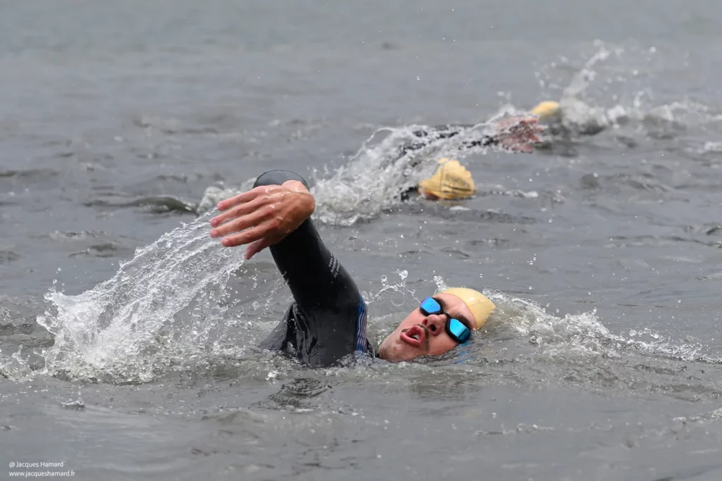 Détail d'un nageur en plein effort : focus sur les éclaboussures et le mouvement de l'eau au Triathlon de Chamouille