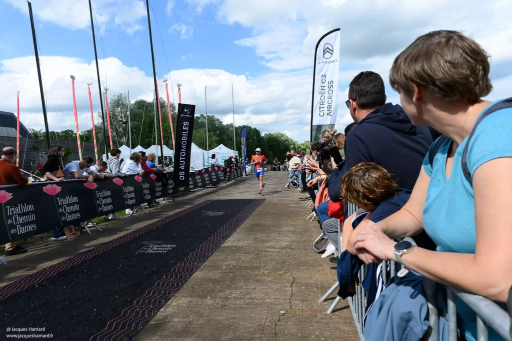 Passage de la ligne d'arrivée : émotion et cri de victoire d'un triathlète après l'épreuve.