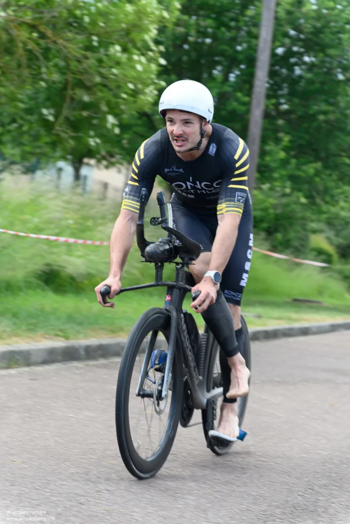 Fin de l'épreuve cycliste : athlète effectuant une descente de vélo dynamique avant la course à pied.