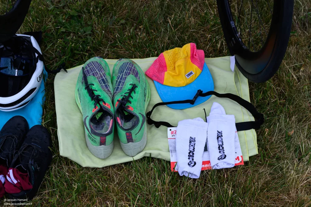 Détail du matériel de triathlon organisé pour la transition : chaussures de vélo et casque prêts pour l'effort.