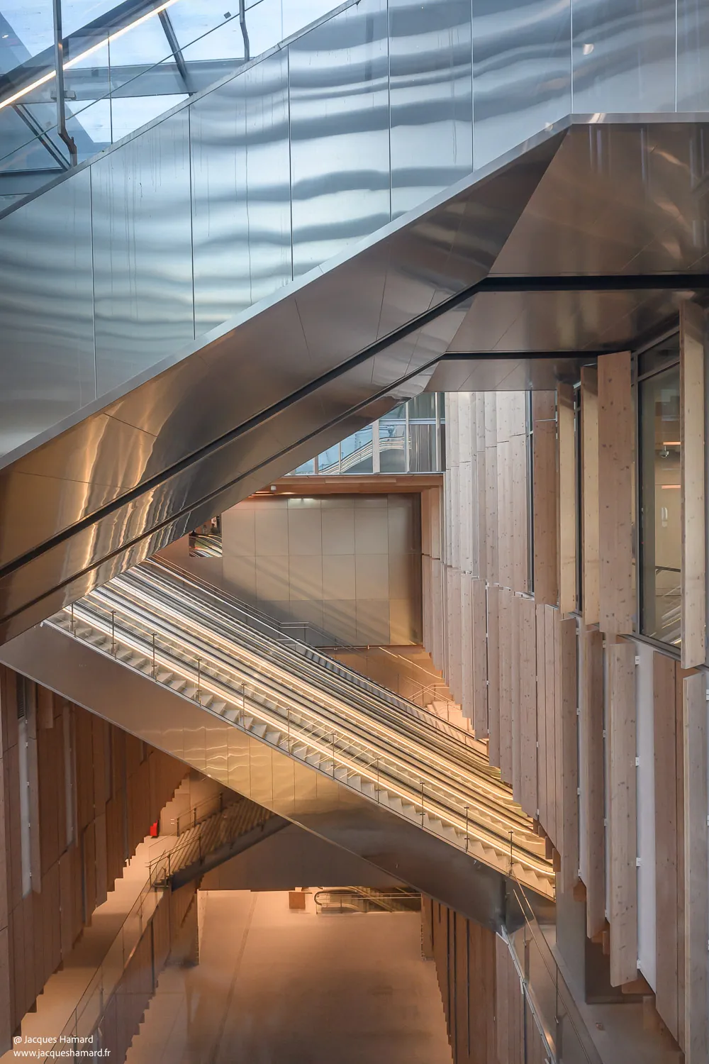 Atrium Saint-Denis Pleyel — Escalator inox et lamelles bois — lumière — Jacques Hamard