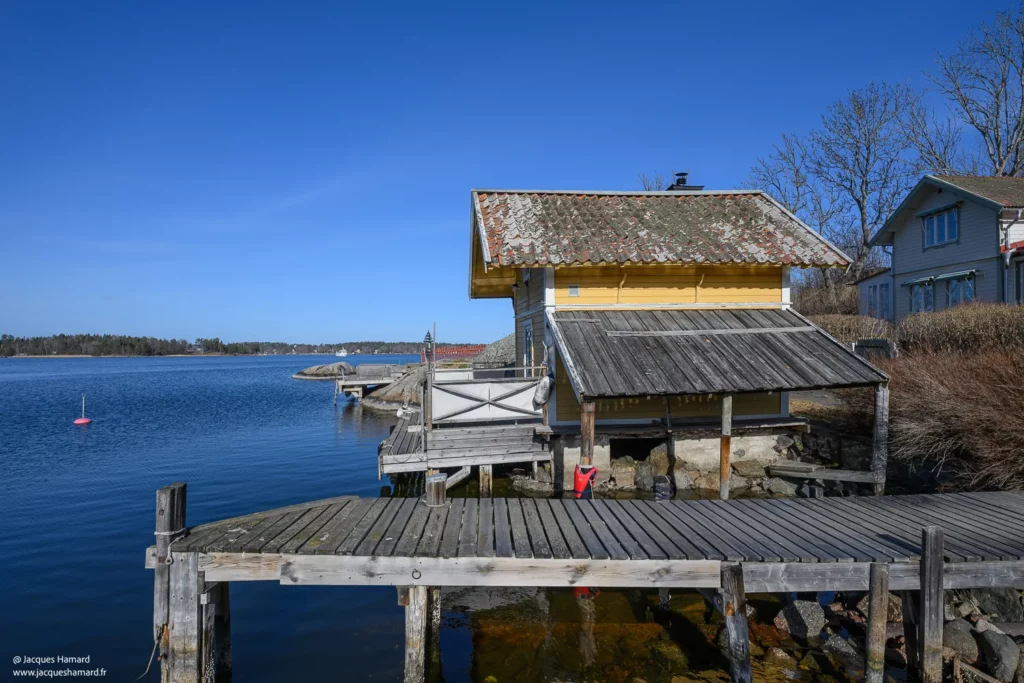 Cabane en bois jaune au bord de l'eau dans l'archipel lors d'un voyage à Stockholm.