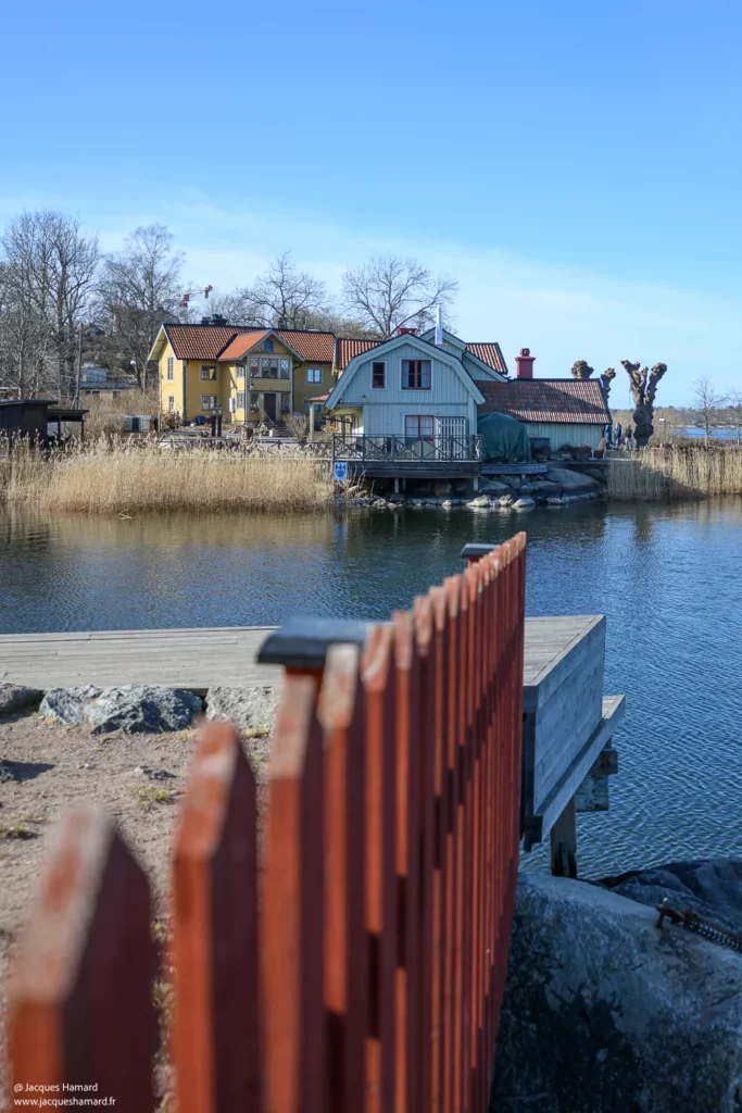 Clôture rouge et maisons en bois au bord du rivage à Stockholm.