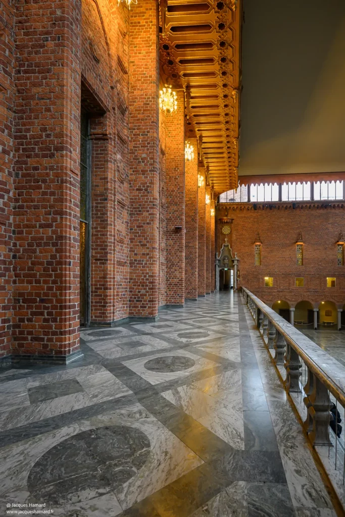 Galerie intérieure en briques rouges et sol en marbre de l'Hôtel de Ville de Stockholm